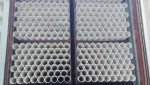 A shipping container is filled with stacks of white PVC pipes, neatly arranged in rows.